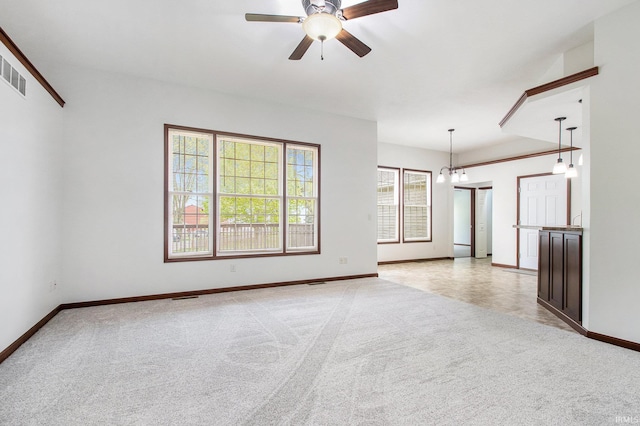 300 E Wabash Ave, Wakarusa, IN 46573 - unfurnished living room featuring baseboards, light carpet, and ceiling fan with notable chandelier