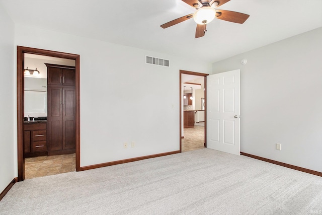 300 E Wabash Ave, Wakarusa, IN 46573 - unfurnished bedroom featuring a ceiling fan, light colored carpet, visible vents, baseboards, and ensuite bath