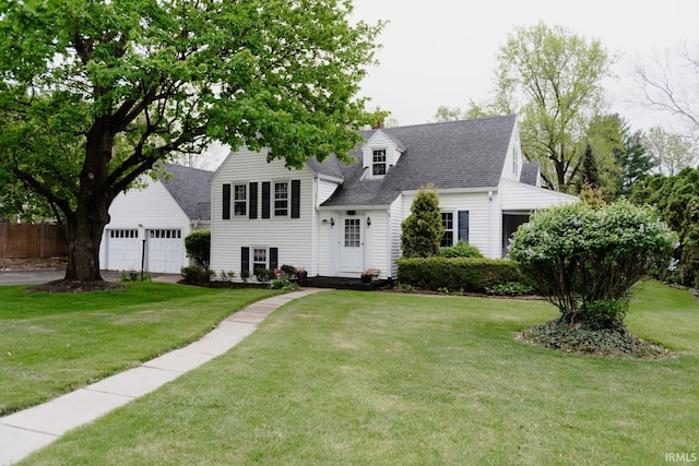 view of front of house with fence, a front lawn, roof with shingles, and a garage