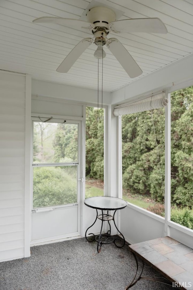 unfurnished sunroom featuring a ceiling fan