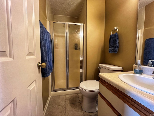 full bath featuring vanity, toilet, a textured ceiling, tile patterned floors, and a stall shower
