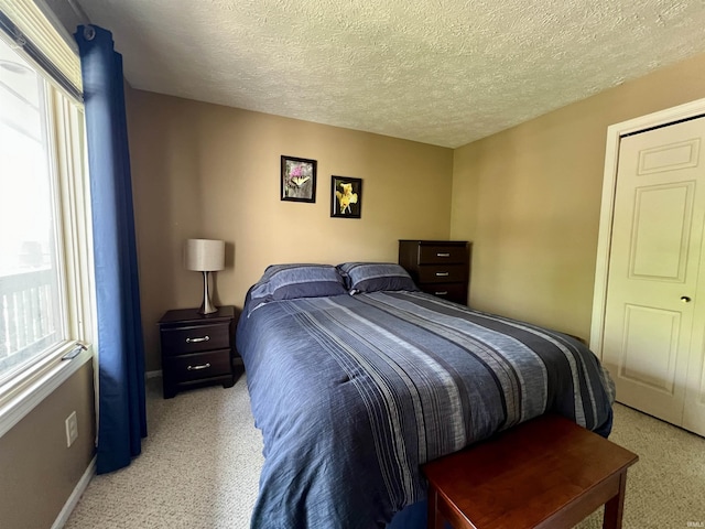 bedroom with baseboards, carpet flooring, and a textured ceiling