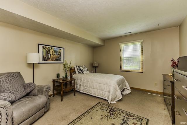 carpeted bedroom featuring a textured ceiling and baseboards