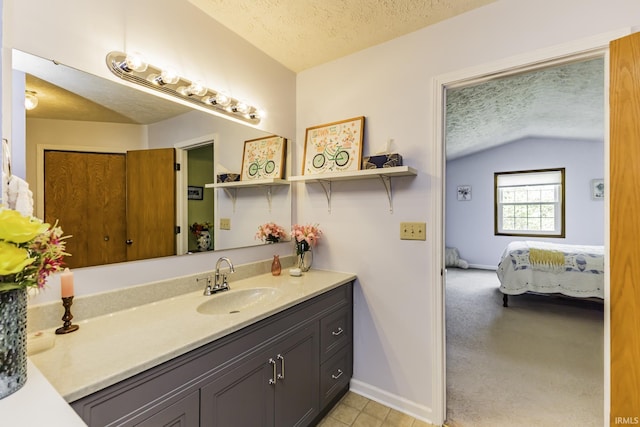 bathroom featuring connected bathroom, vanity, a textured ceiling, baseboards, and vaulted ceiling