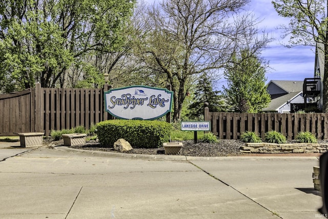 community / neighborhood sign featuring fence