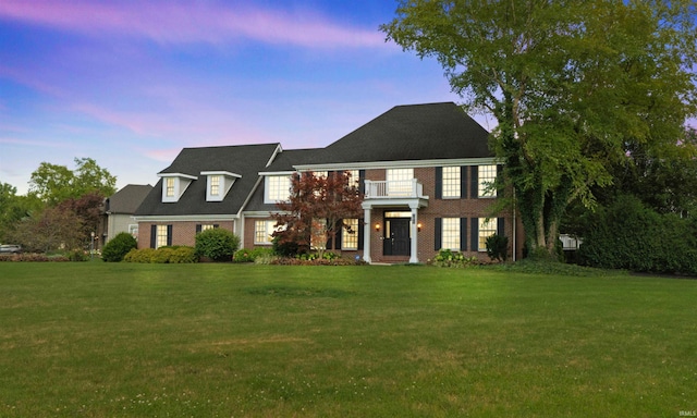 view of front of house with brick siding and a front lawn