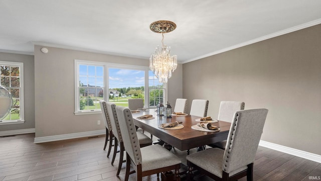 dining space with crown molding, baseboards, a chandelier, and wood finished floors