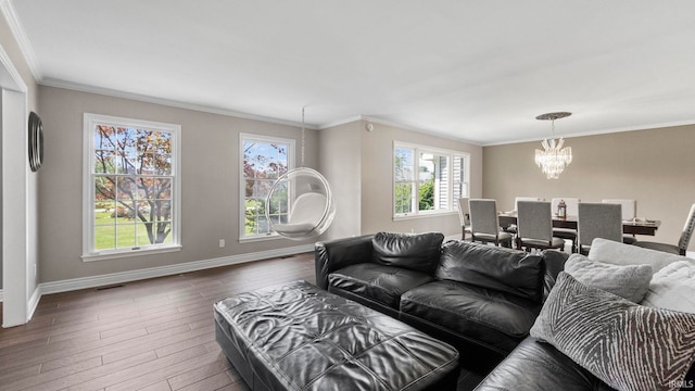 living room with a chandelier, hardwood / wood-style floors, baseboards, visible vents, and ornamental molding