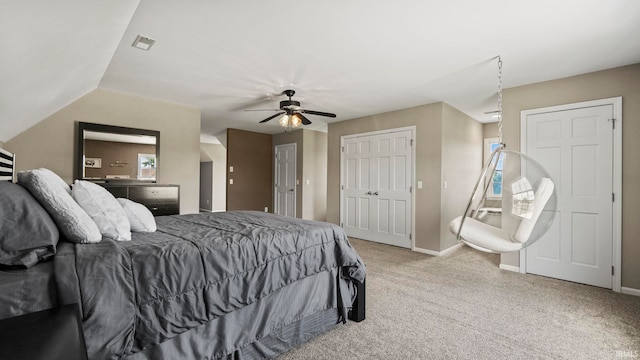carpeted bedroom featuring visible vents, a ceiling fan, baseboards, and two closets