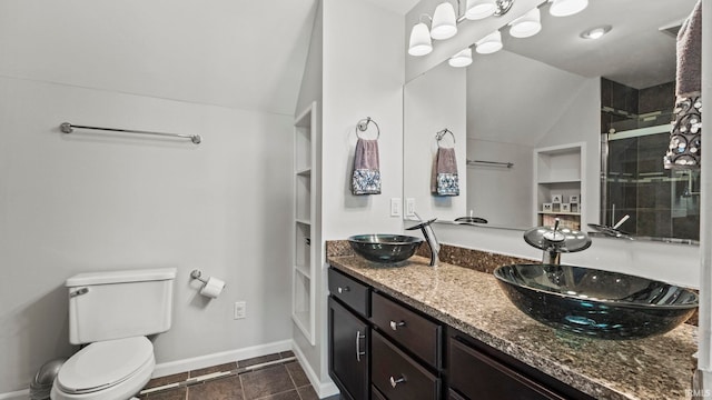 bathroom with toilet, vaulted ceiling, a sink, and a stall shower