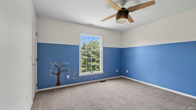spare room with carpet flooring, a ceiling fan, baseboards, and visible vents