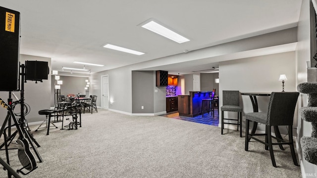 interior space featuring carpet floors, baseboards, and bar area