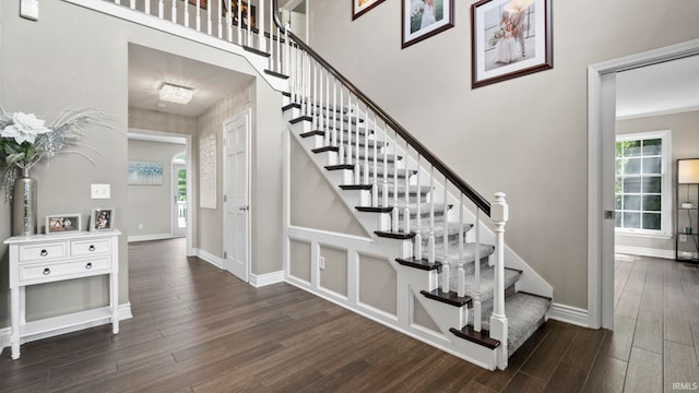 stairs featuring a healthy amount of sunlight, baseboards, and wood finished floors
