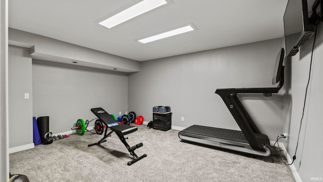 workout room featuring baseboards and carpet flooring
