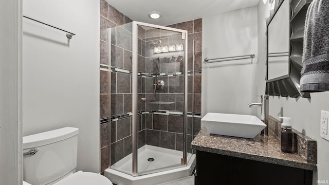 bathroom with vanity, toilet, and a stall shower