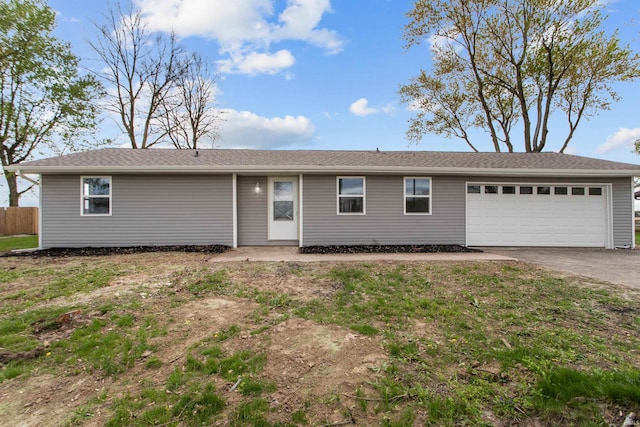 ranch-style house featuring fence, driveway, and a garage