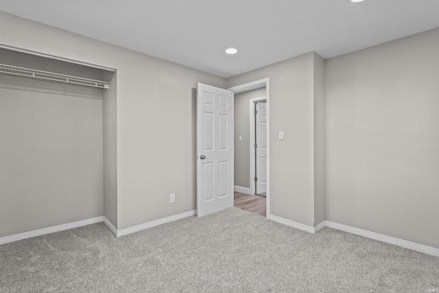unfurnished bedroom featuring a closet, baseboards, carpet flooring, and recessed lighting