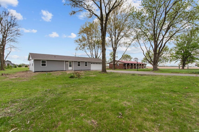 view of front of home with an attached garage, driveway, and a front yard