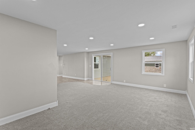 below grade area featuring recessed lighting, baseboards, and light carpet