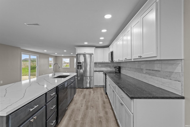kitchen with visible vents, recessed lighting, white cabinets, a sink, and stainless steel appliances