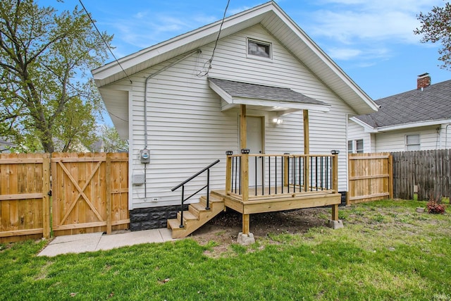 714 S 25th St, South Bend, IN 46615 - back of property with a fenced backyard, a wooden deck, a yard, and roof with shingles