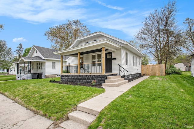 714 S 25th St, South Bend, IN 46615 - view of front of home with a porch, fence, and a front lawn
