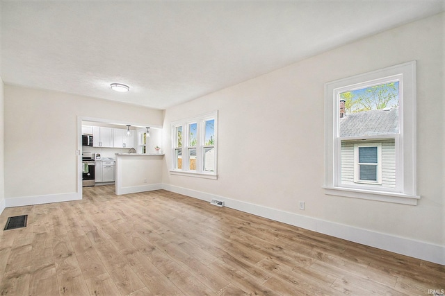 714 S 25th St, South Bend, IN 46615 - unfurnished living room with baseboards, visible vents, and light wood-type flooring