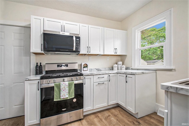 714 S 25th St, South Bend, IN 46615 - kitchen featuring light wood-type flooring, white cabinetry, and stainless steel appliances