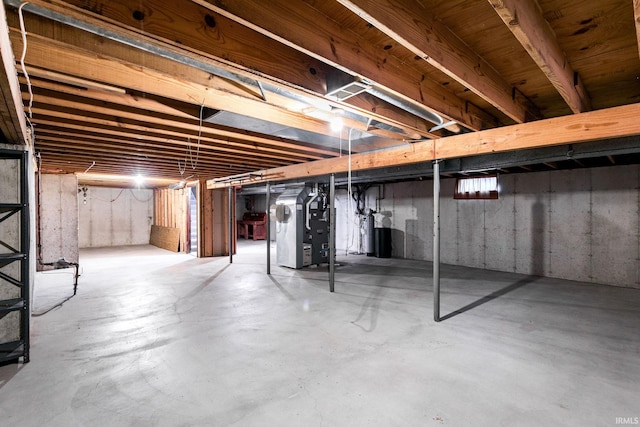 unfinished basement featuring heating unit