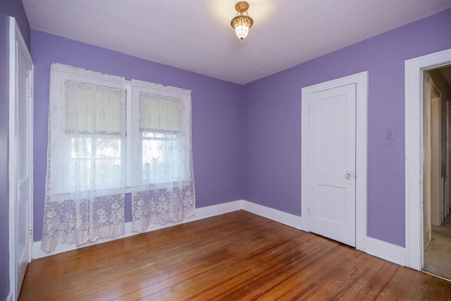 empty room with baseboards and wood finished floors