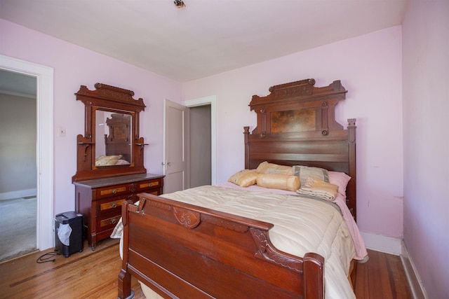 bedroom featuring baseboards and light wood-style flooring