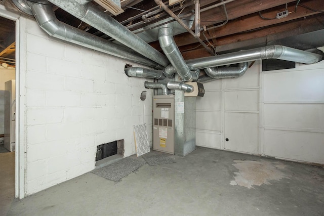 unfinished basement with concrete block wall and heating unit