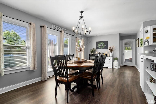 dining room with baseboards, a wealth of natural light, dark wood finished floors, and a notable chandelier