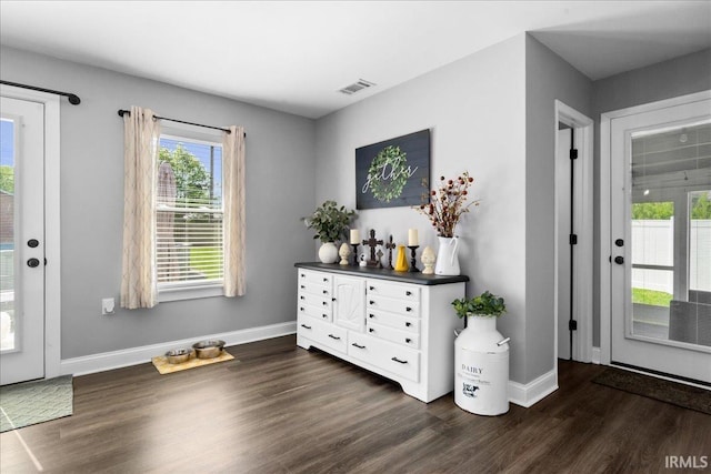 doorway featuring dark wood-style flooring, baseboards, and visible vents