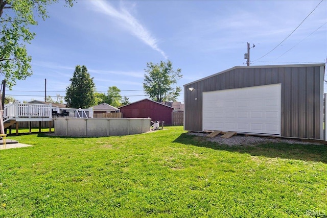 view of yard featuring an outdoor pool, an outbuilding, and a deck