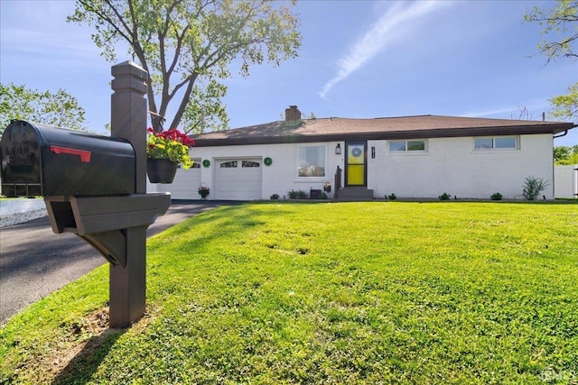 ranch-style home featuring an attached garage, aphalt driveway, a front yard, entry steps, and a chimney