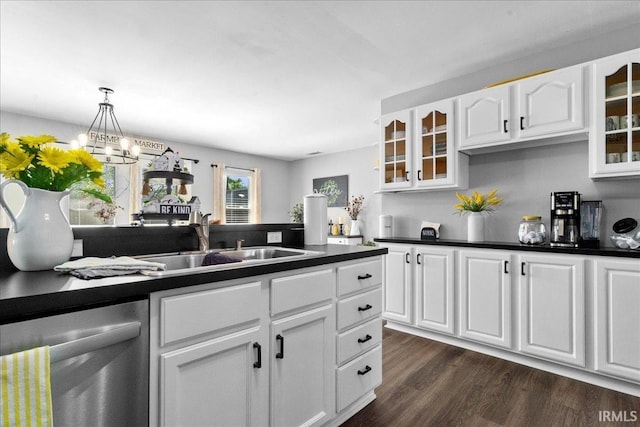 kitchen with stainless steel dishwasher, dark countertops, glass insert cabinets, and a sink