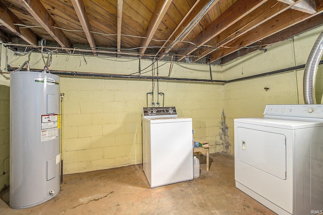 washroom with laundry area, washing machine and dryer, and electric water heater