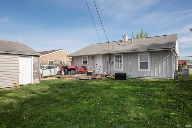 rear view of house with a wooden deck, fence, board and batten siding, a lawn, and central air condition unit