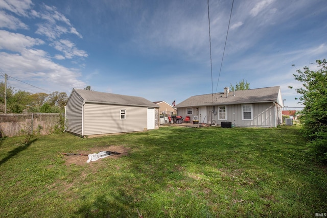 back of property featuring a yard, fence, board and batten siding, and an outdoor structure