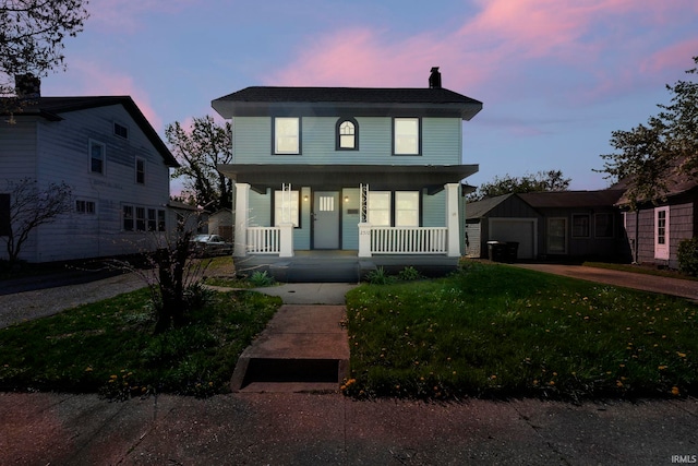 view of front of home featuring covered porch, a chimney, a lawn, a garage, and concrete driveway