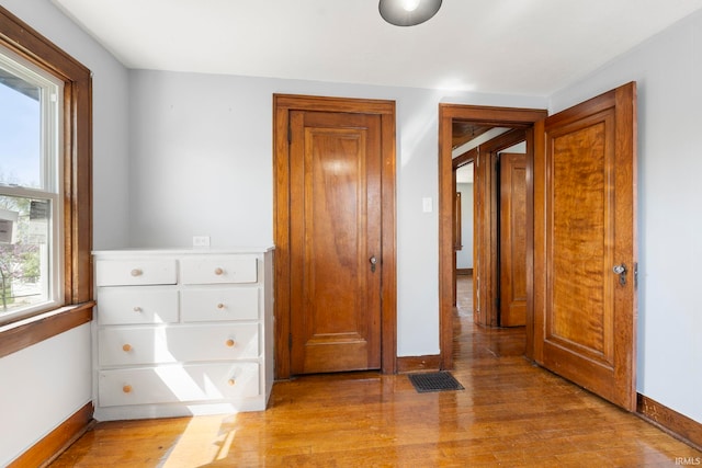 unfurnished bedroom with baseboards, visible vents, and light wood-type flooring
