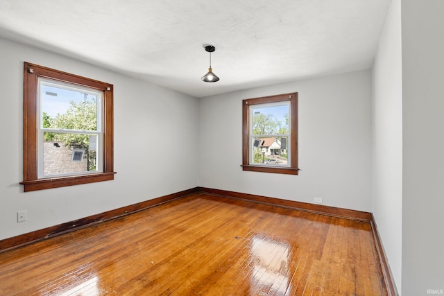 spare room featuring baseboards and hardwood / wood-style floors