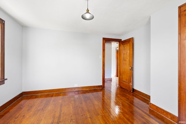 empty room with baseboards and hardwood / wood-style flooring