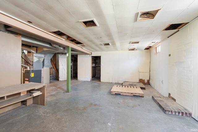 unfinished basement with visible vents and heating unit