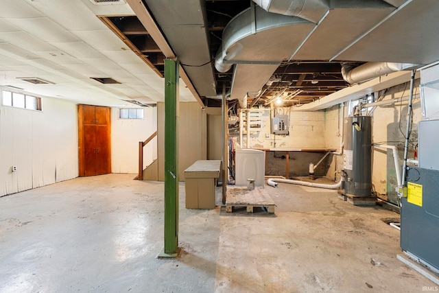 below grade area featuring electric panel, gas water heater, washer / clothes dryer, and a wealth of natural light
