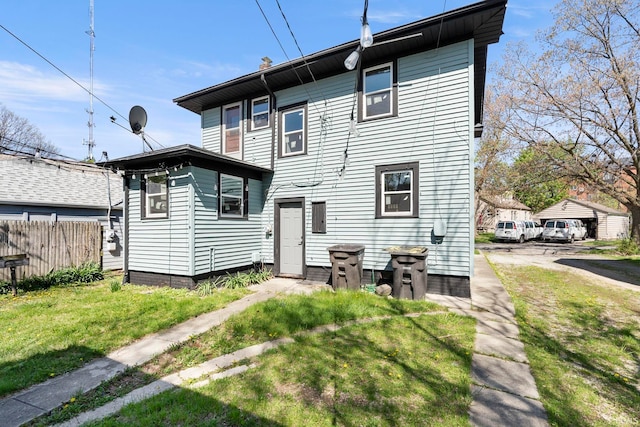 rear view of property with a lawn and fence