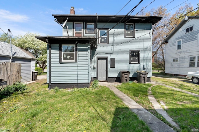 back of house with a chimney and a yard