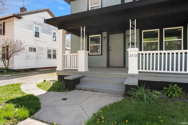 entrance to property featuring covered porch and a chimney