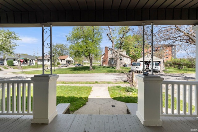 wooden deck with a residential view and covered porch